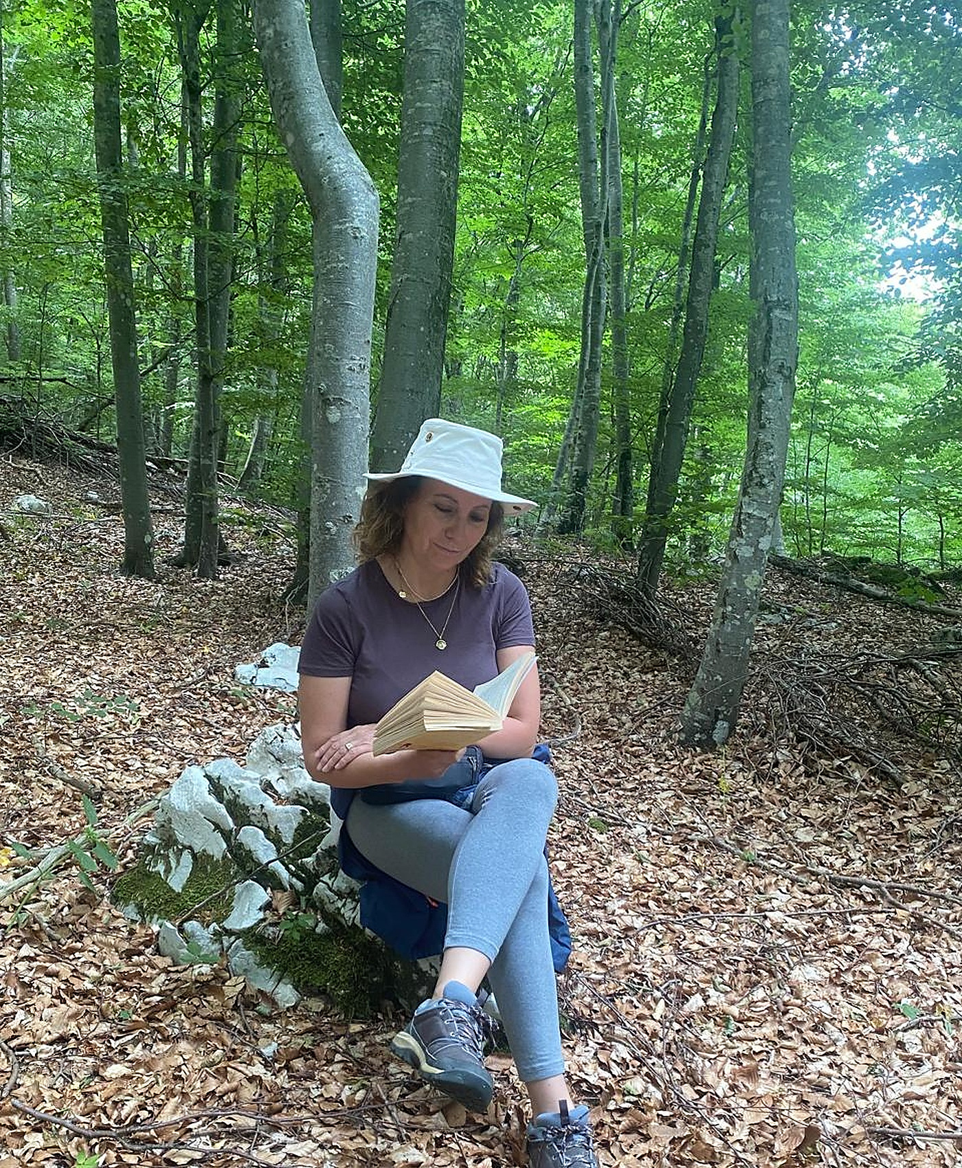 Sara reading quietly in a woodland setting